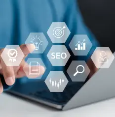 A person's hand hovers over a laptop, with a hexagonal overlay of digital icons including a target, a lightbulb, a checklist, and "SEO" at the center, symbolizing a digital strategy